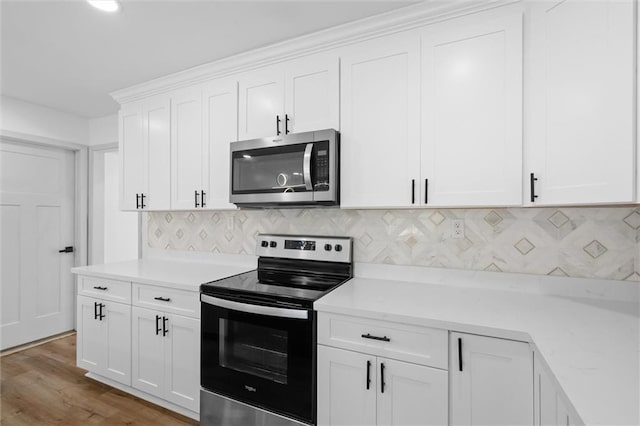 3158 Lees Ln, Mobile, AL 36693 - kitchen featuring light stone counters, white cabinets, decorative backsplash, appliances with stainless steel finishes, and wood finished floors