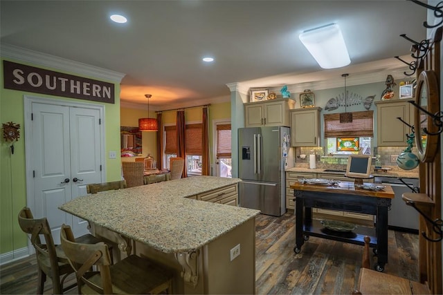 kitchen with decorative backsplash, stainless steel fridge with ice dispenser, a center island, and pendant lighting