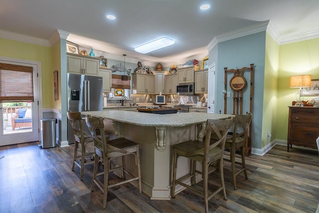 kitchen featuring a center island, a kitchen breakfast bar, hanging light fixtures, light stone countertops, and appliances with stainless steel finishes