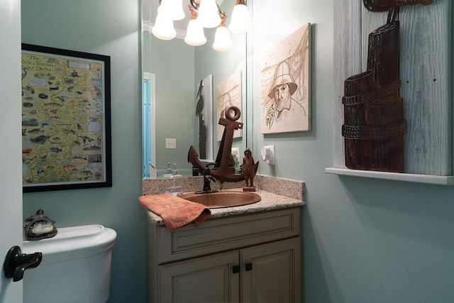 bathroom with vanity, a chandelier, and toilet