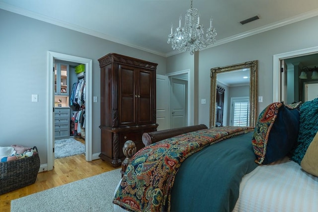 bedroom with crown molding, a closet, a notable chandelier, and light wood-type flooring