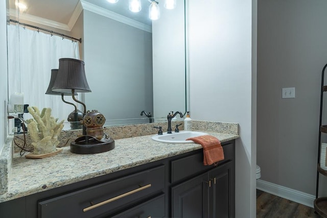 bathroom with hardwood / wood-style flooring, vanity, toilet, and ornamental molding