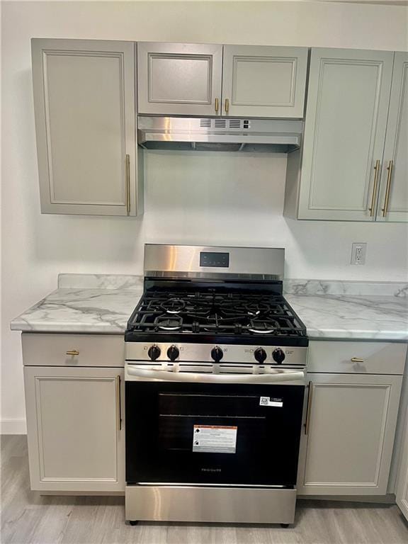 3905 Charmaine Cir E, Mobile, AL 36605 - kitchen featuring stainless steel gas range oven, under cabinet range hood, light stone countertops, and light wood finished floors