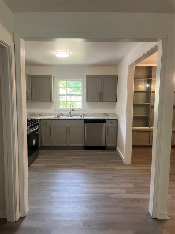 3905 Charmaine Cir E, Mobile, AL 36605 - kitchen with dishwasher, range, gray cabinetry, a sink, and wood finished floors