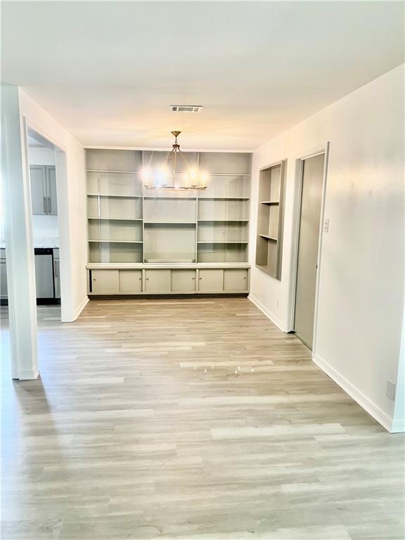 3905 Charmaine Cir E, Mobile, AL 36605 - unfurnished dining area with baseboards, built in features, wood finished floors, and a chandelier