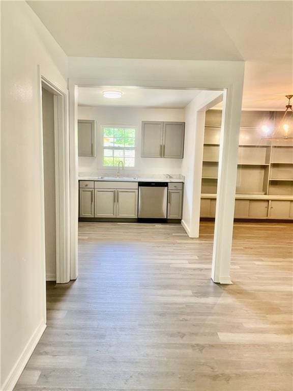 3905 Charmaine Cir E, Mobile, AL 36605 - kitchen with stainless steel dishwasher, gray cabinets, a sink, light wood-style floors, and baseboards