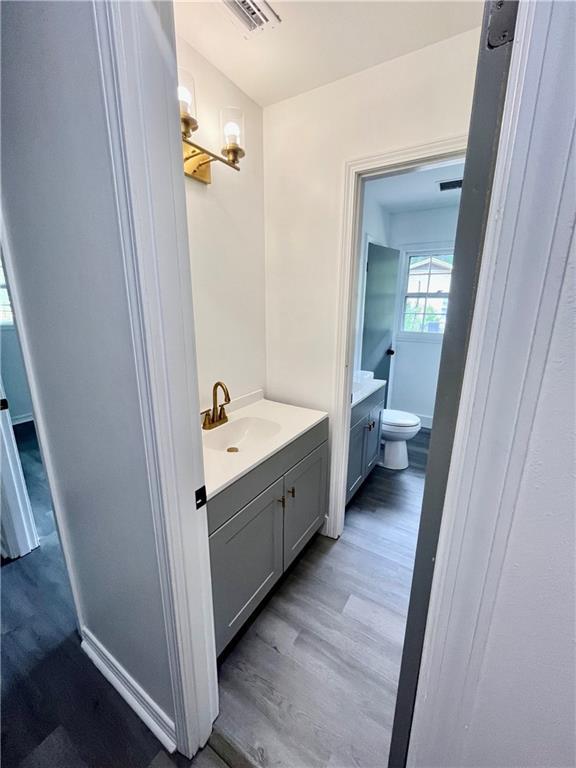 3905 Charmaine Cir E, Mobile, AL 36605 - bathroom featuring vanity, wood finished floors, and toilet