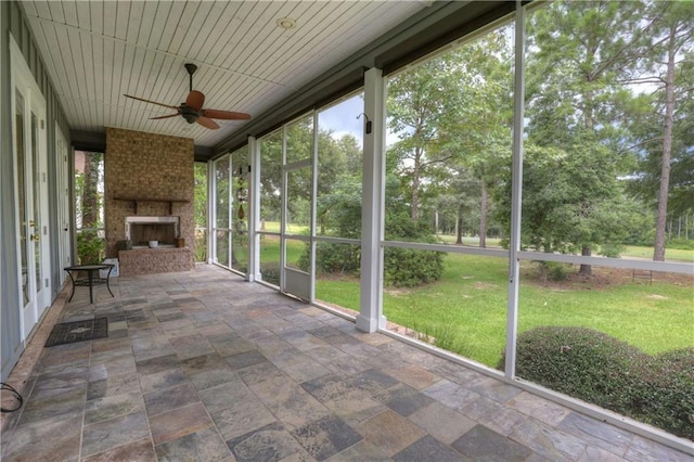 unfurnished sunroom featuring ceiling fan