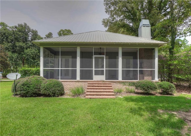 back of house with a sunroom and a lawn