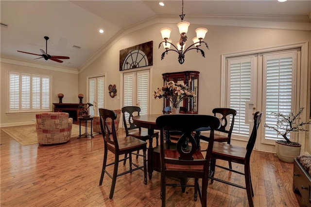 dining room featuring hardwood / wood-style flooring, ornamental molding, vaulted ceiling, and a wealth of natural light