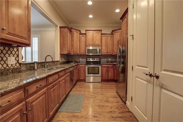 kitchen featuring tasteful backsplash, sink, dark stone counters, stainless steel appliances, and crown molding