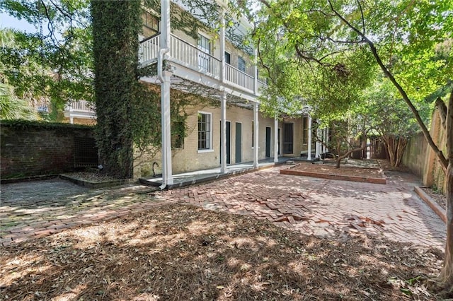 255 N Conception St, Mobile, AL 36603 - rear view of house featuring a patio, a fenced backyard, brick siding, and a balcony