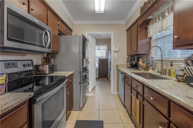 2647 Weems Dr, Mobile, AL 36607 - kitchen featuring appliances with stainless steel finishes, light tile patterned floors, crown molding, a textured ceiling, and light stone countertops