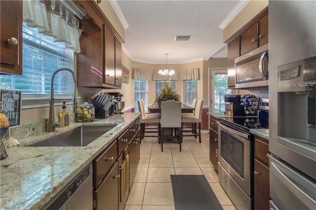 2647 Weems Dr, Mobile, AL 36607 - kitchen with stainless steel appliances, ornamental molding, a chandelier, light tile patterned floors, and a textured ceiling