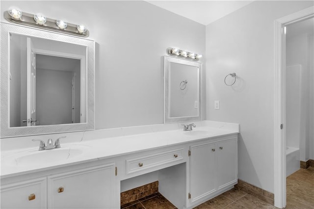 bathroom with tile patterned floors, a tub to relax in, and vanity