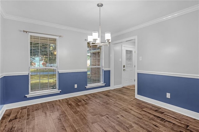 unfurnished dining area featuring hardwood / wood-style floors, ornamental molding, and an inviting chandelier