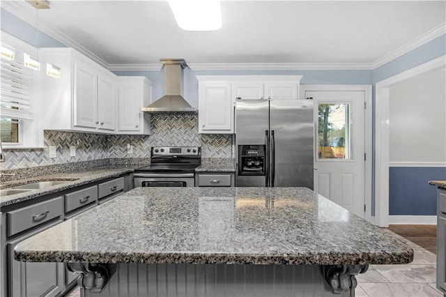 kitchen with a center island, a kitchen breakfast bar, wall chimney exhaust hood, white cabinetry, and stainless steel appliances