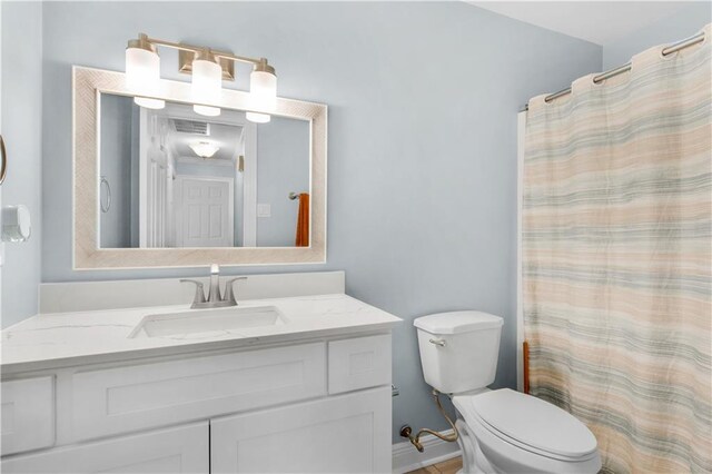 bathroom featuring vanity, curtained shower, and toilet