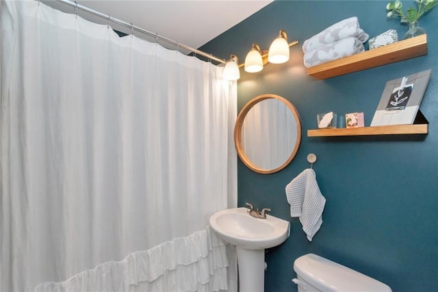 bathroom featuring a shower with shower curtain and toilet