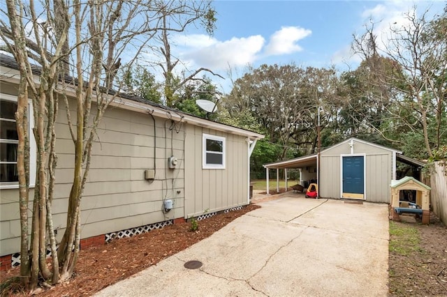 view of outbuilding with a carport and concrete driveway