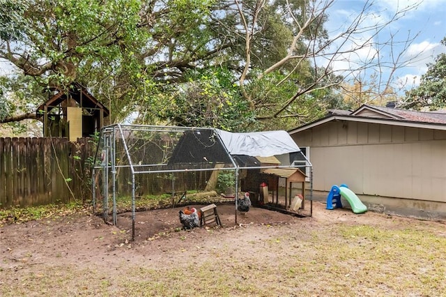 view of yard featuring an outbuilding, fence, and exterior structure