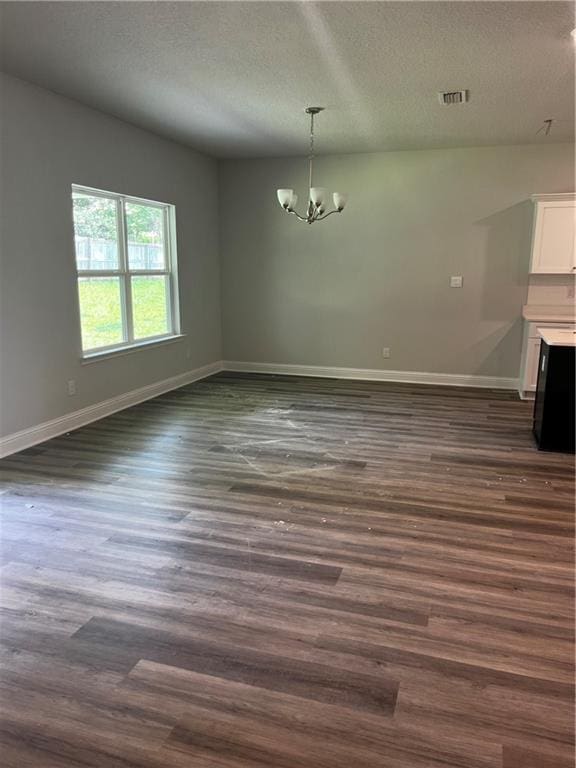 7324 Hawkins Mnr N, Mobile, AL 36695 - unfurnished dining area with a chandelier, a textured ceiling, baseboards, and dark wood-style flooring
