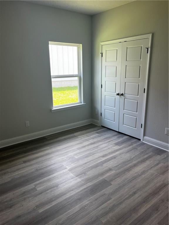 7324 Hawkins Mnr N, Mobile, AL 36695 - unfurnished bedroom featuring dark wood-style floors, baseboards, and a closet