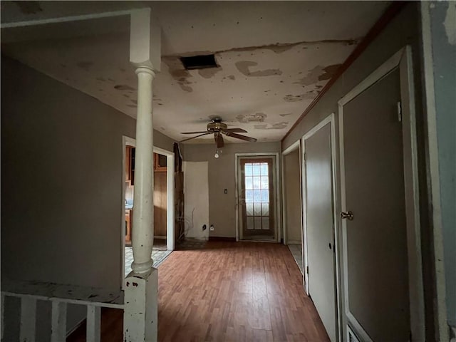 misc room with ceiling fan, wood-type flooring, and ornate columns