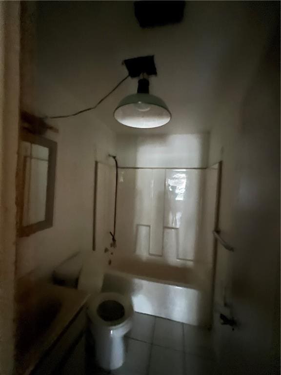 full bathroom featuring washtub / shower combination, tile patterned floors, toilet, and vanity