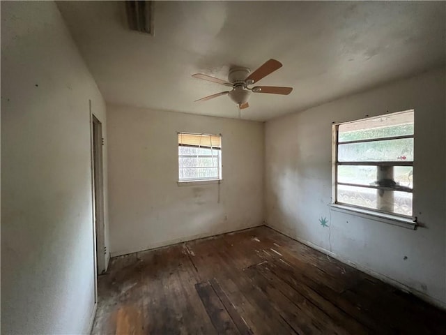 spare room with dark wood-type flooring, ceiling fan, and plenty of natural light