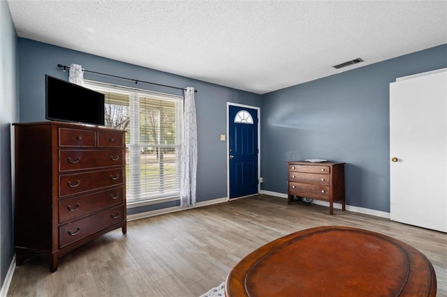 entrance foyer with light wood-type flooring and a textured ceiling