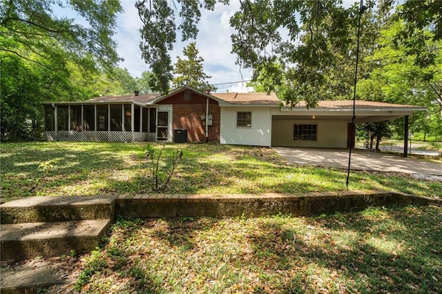 4615 Sunset Dr N, Mobile, AL 36608 - rear view of house with a sunroom, an attached carport, a yard, driveway, and central AC