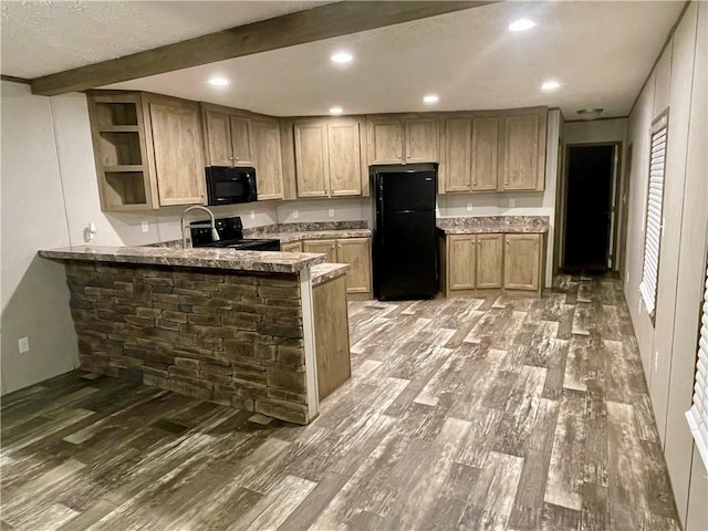 kitchen featuring light brown cabinetry, beamed ceiling, black appliances, hardwood / wood-style flooring, and kitchen peninsula