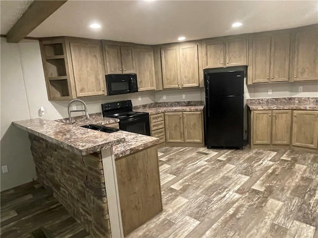 kitchen with beamed ceiling, black appliances, sink, dark stone countertops, and kitchen peninsula