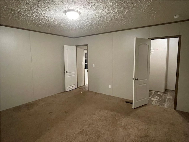 carpeted empty room featuring a textured ceiling