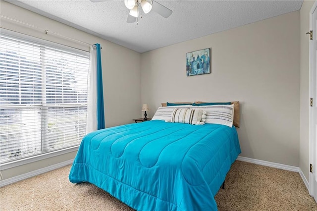 bedroom featuring a textured ceiling, ceiling fan, and carpet