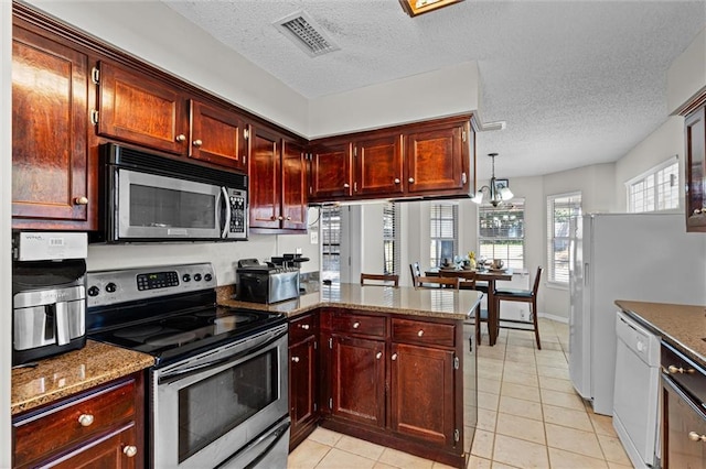 kitchen featuring decorative light fixtures, stainless steel appliances, kitchen peninsula, a notable chandelier, and light tile patterned flooring