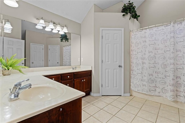 bathroom featuring tile patterned flooring, vanity, and vaulted ceiling