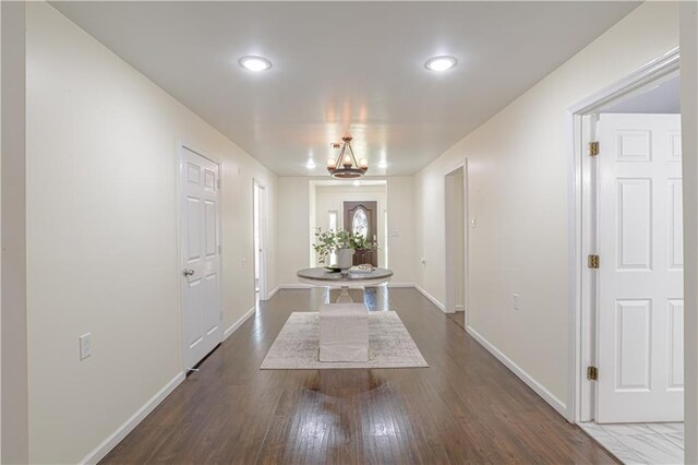 interior space with dark wood-type flooring and an inviting chandelier