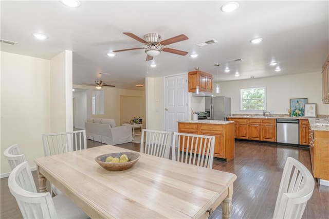 dining space featuring ceiling fan, dark hardwood / wood-style flooring, and sink