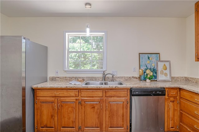 kitchen with appliances with stainless steel finishes, sink, and pendant lighting