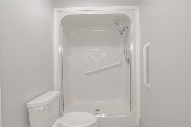 bathroom featuring a shower and toilet