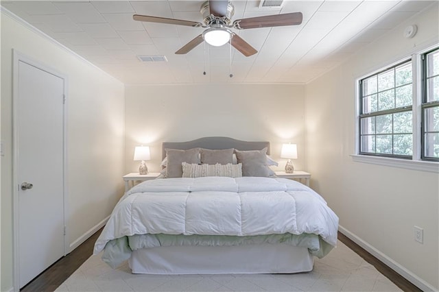 bedroom featuring ceiling fan, hardwood / wood-style flooring, and ornamental molding