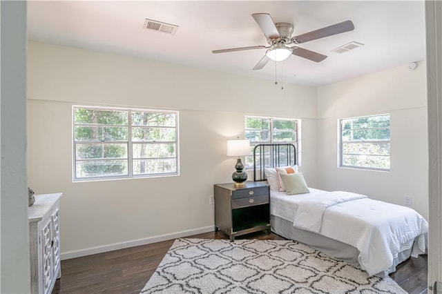 bedroom featuring ceiling fan, wood-type flooring, and multiple windows