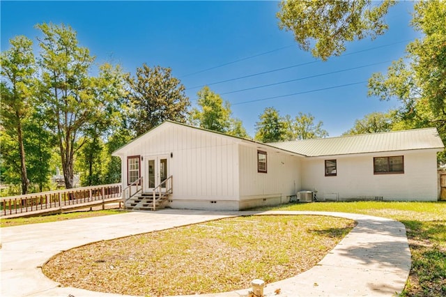 back of property with a lawn and a patio