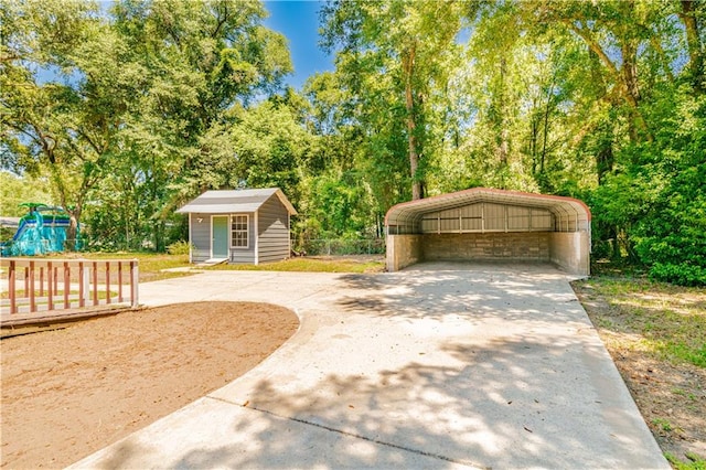 view of front of home featuring a carport and an outbuilding