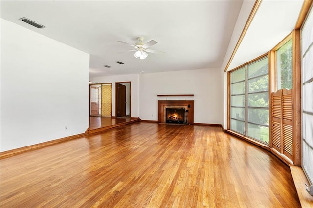 unfurnished living room with a fireplace, ceiling fan, and light hardwood / wood-style floors