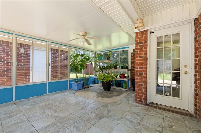 unfurnished sunroom with beam ceiling and ceiling fan