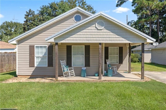 bungalow-style home featuring covered porch and a front yard