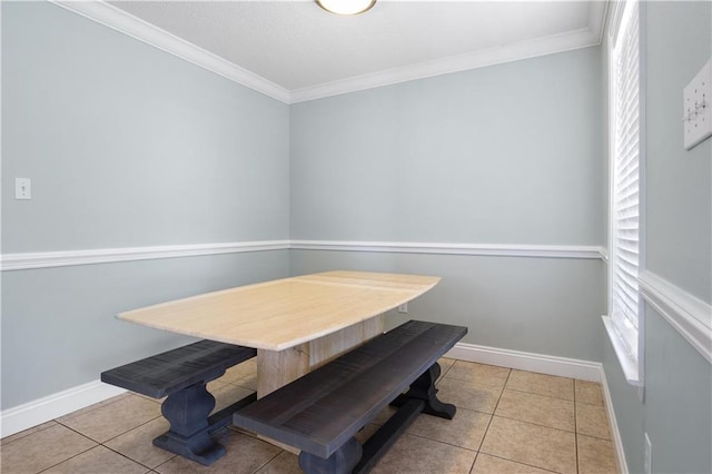 dining space with crown molding and light tile patterned flooring